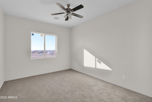 carpeted spare room with ceiling fan