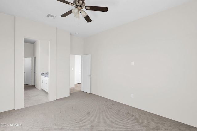 unfurnished bedroom with ensuite bath, ceiling fan, and light carpet