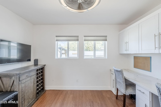 4402 E Montecito Ave, Phoenix, AZ 85018 - office area featuring built in desk, baseboards, and light wood-style floors