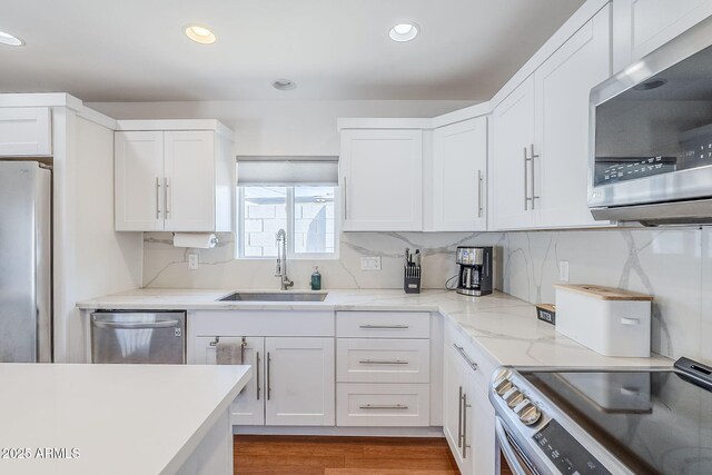 4402 E Montecito Ave, Phoenix, AZ 85018 - kitchen with stainless steel appliances, a sink, white cabinetry, recessed lighting, and wood finished floors
