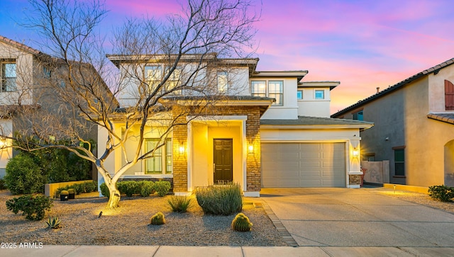 view of front facade featuring stucco siding, a garage, and driveway