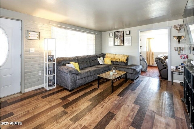 living area with baseboards and wood finished floors