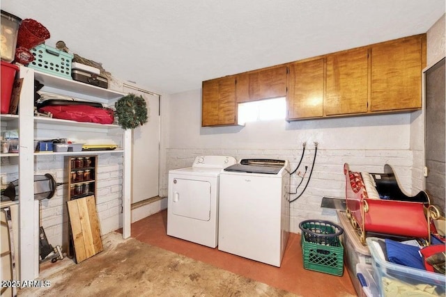 clothes washing area with cabinet space and washing machine and dryer