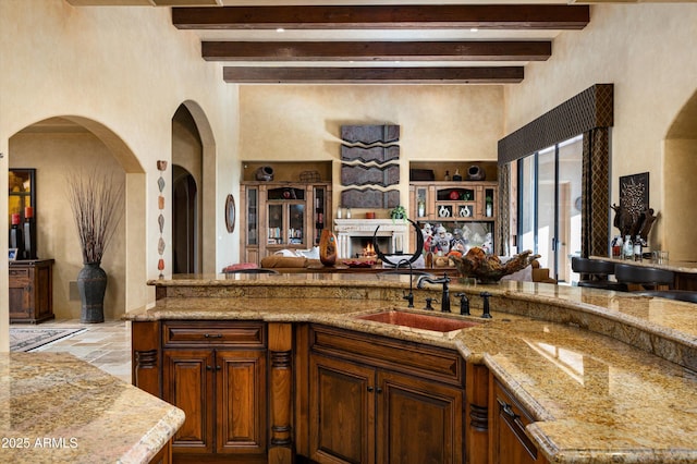 11457 E Salero Dr, Scottsdale, AZ 85262 - kitchen featuring a high ceiling, a sink, open floor plan, beam ceiling, and light stone countertops