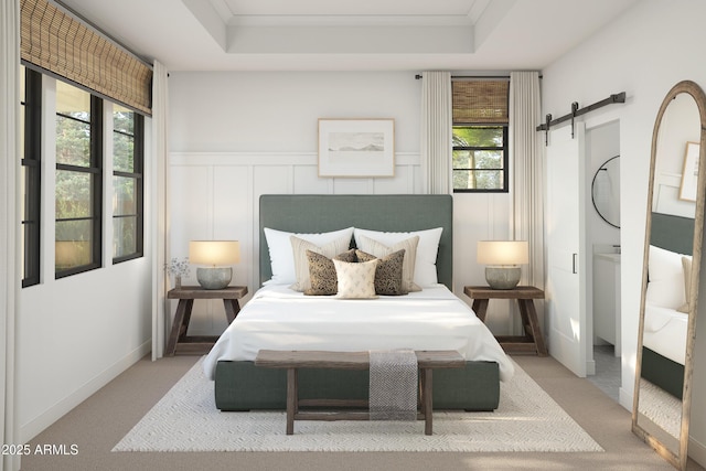 carpeted bedroom with a barn door and a tray ceiling