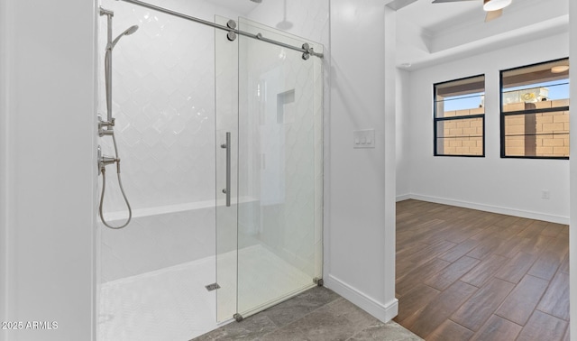 bathroom with a shower with door, hardwood / wood-style flooring, and ceiling fan