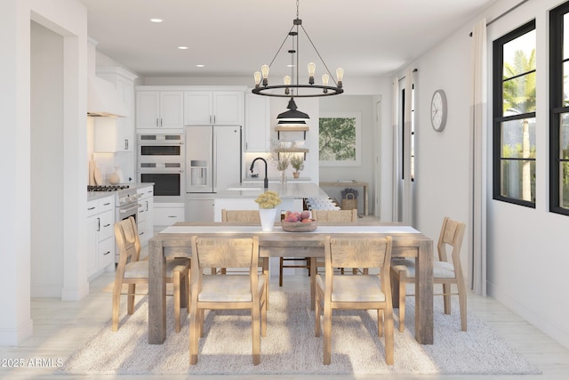 dining area with sink, a wealth of natural light, a chandelier, and light hardwood / wood-style flooring