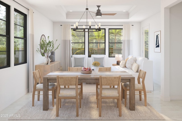 dining space featuring an inviting chandelier, a healthy amount of sunlight, and a raised ceiling