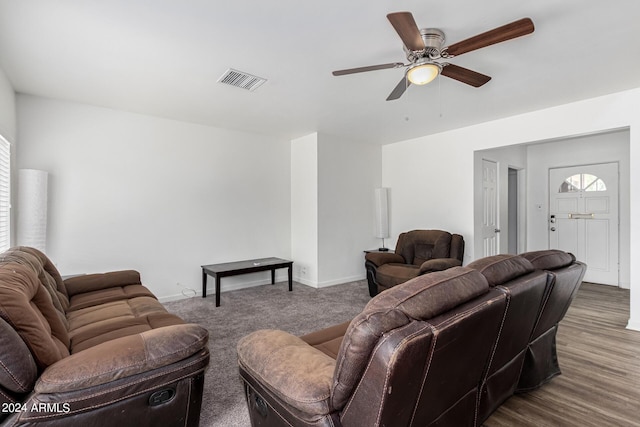 living room with a ceiling fan, visible vents, baseboards, and wood finished floors