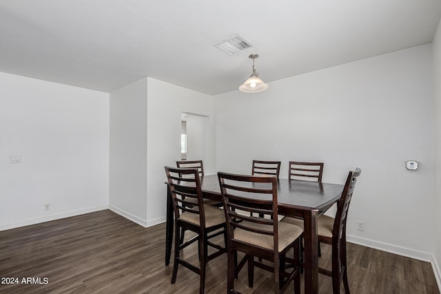 dining space with dark wood-type flooring, visible vents, and baseboards