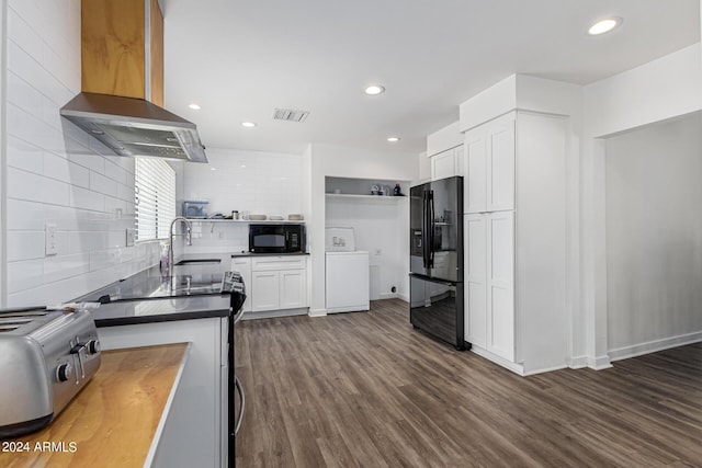 kitchen with wall chimney exhaust hood, open shelves, visible vents, a sink, and black appliances