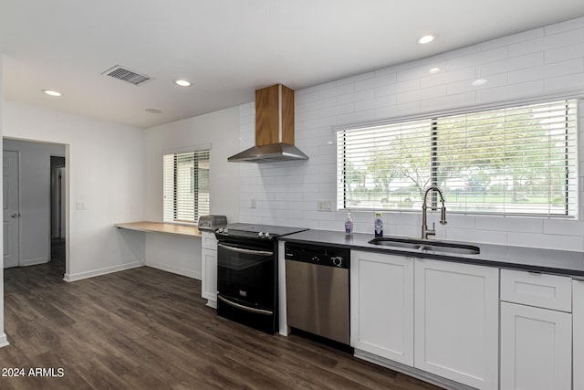 kitchen featuring black electric range oven, visible vents, stainless steel dishwasher, a sink, and wall chimney exhaust hood