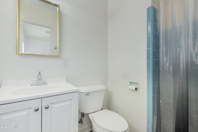 bathroom featuring toilet, walk in shower, and vanity