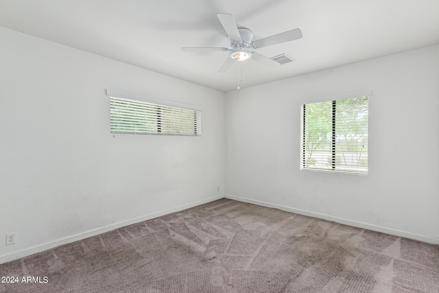 carpeted spare room featuring ceiling fan