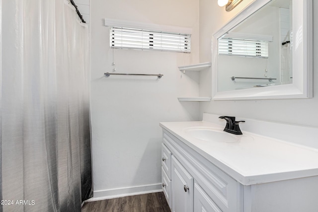 bathroom with a shower with curtain, wood finished floors, vanity, and baseboards