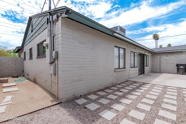 view of property exterior with a patio and fence