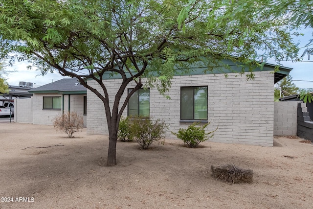 view of front of house featuring fence and brick siding