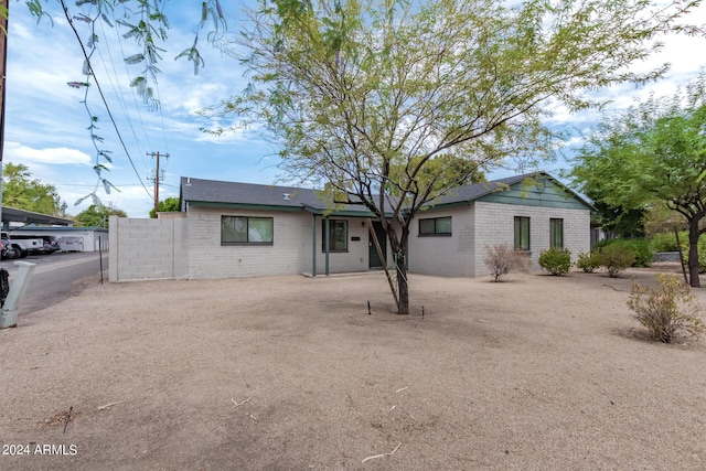 ranch-style house with dirt driveway and brick siding