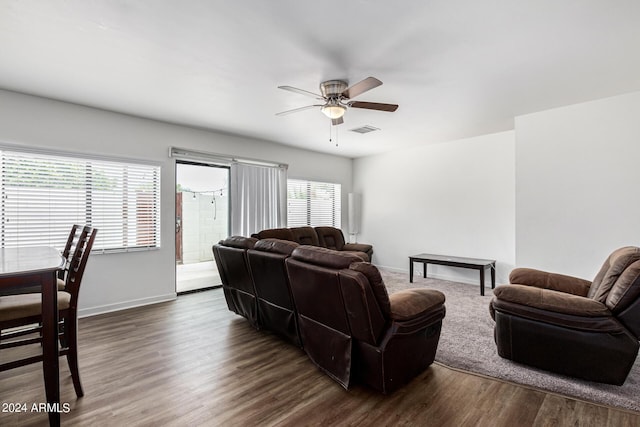 living area with dark wood-style floors, visible vents, baseboards, and a ceiling fan