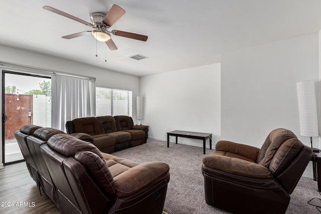 living area featuring baseboards, carpet flooring, visible vents, and a ceiling fan