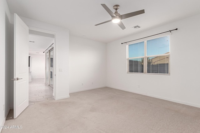 spare room with light colored carpet and ceiling fan