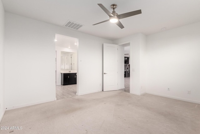 unfurnished room featuring ceiling fan and light colored carpet