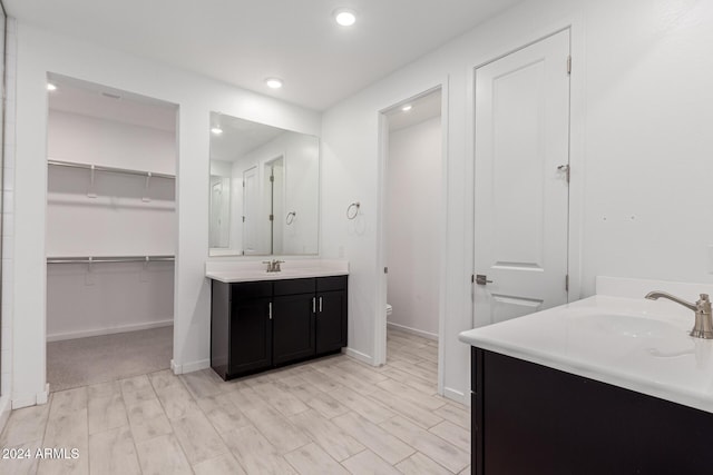 bathroom with hardwood / wood-style flooring, vanity, and toilet