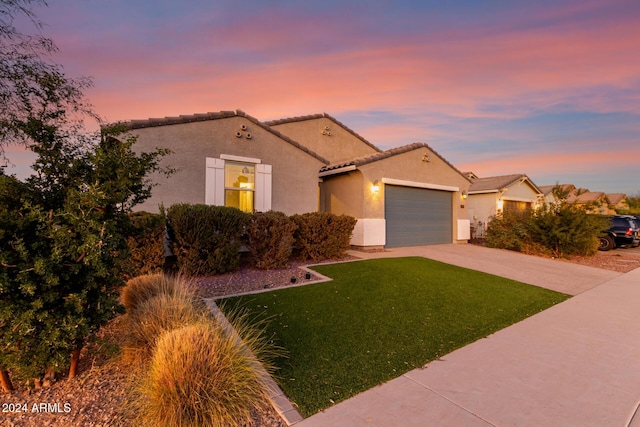 mediterranean / spanish-style home with a lawn and a garage