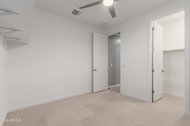 unfurnished bedroom featuring ceiling fan, a closet, and light carpet