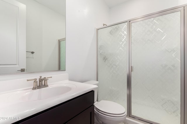 bathroom featuring toilet, walk in shower, and vanity