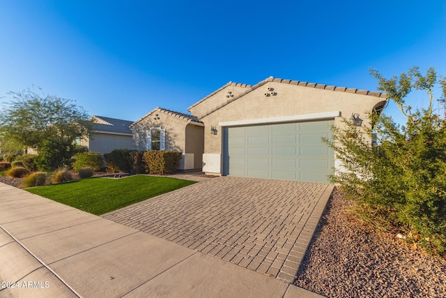 view of front of home with a front lawn and a garage