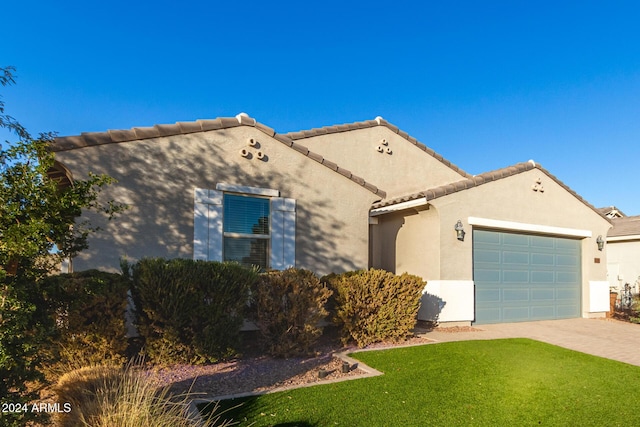 view of front of home with a garage and a front lawn