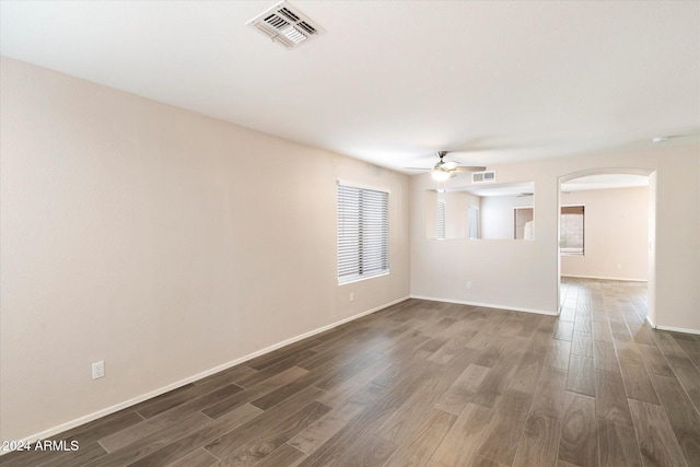 unfurnished room with dark hardwood / wood-style floors, ceiling fan, and a wealth of natural light