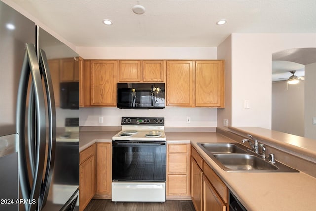 kitchen with stainless steel fridge, white electric range oven, ceiling fan, dark wood-type flooring, and sink