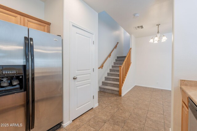 8854 W Aster Dr, Peoria, AZ 85381 - kitchen with stainless steel appliances, a chandelier, light countertops, hanging light fixtures, and baseboards