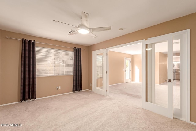 carpeted empty room featuring french doors and ceiling fan