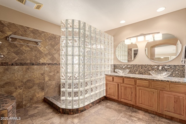 bathroom featuring vanity and tiled shower