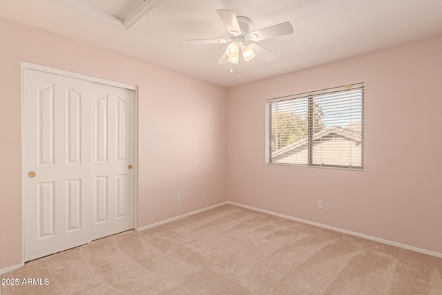 empty room with ceiling fan and light colored carpet