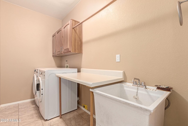 laundry area featuring cabinets, sink, light tile patterned floors, and washer and clothes dryer