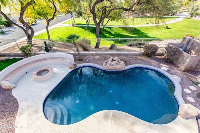 view of swimming pool featuring a fire pit and a lawn