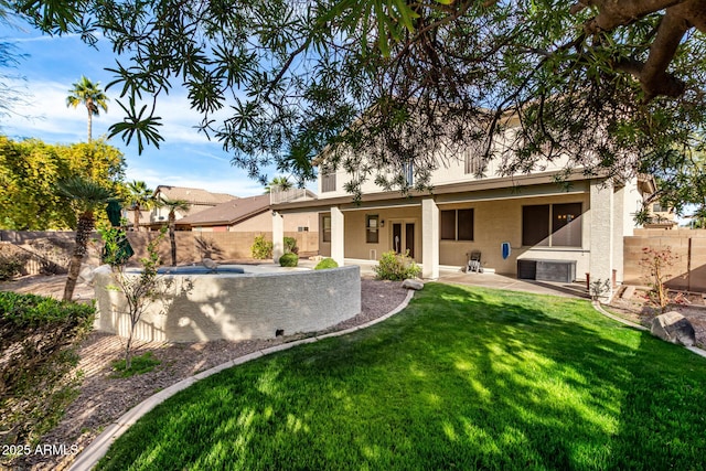 back of property with french doors, a hot tub, a patio area, and a lawn