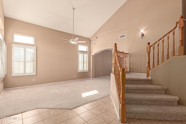 staircase featuring high vaulted ceiling, carpet floors, and ceiling fan