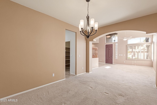 empty room with light colored carpet and a chandelier