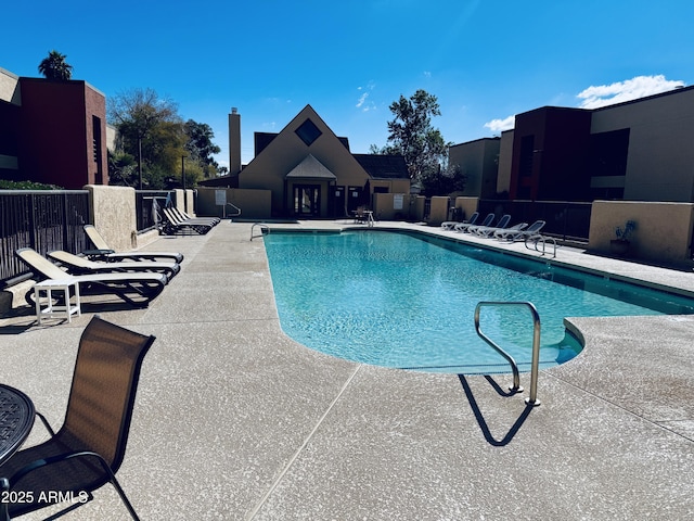 community pool featuring fence and a patio