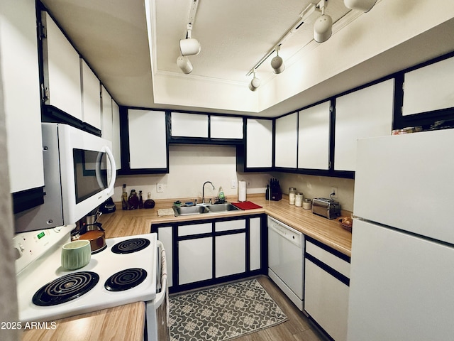 kitchen featuring dark wood finished floors, white appliances, light countertops, and a sink