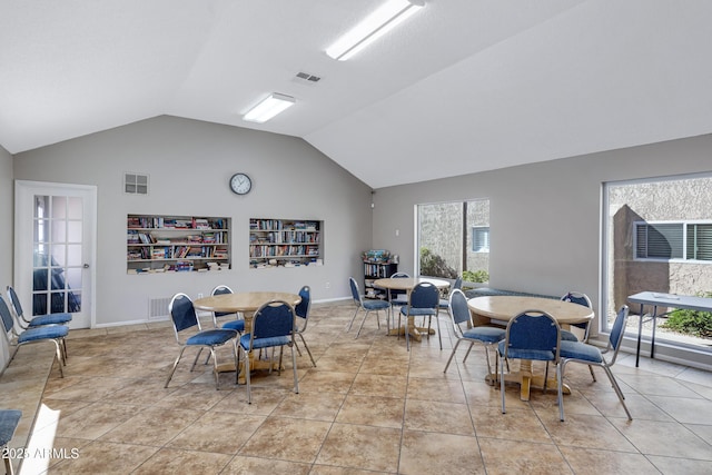 dining area with lofted ceiling and light tile patterned floors