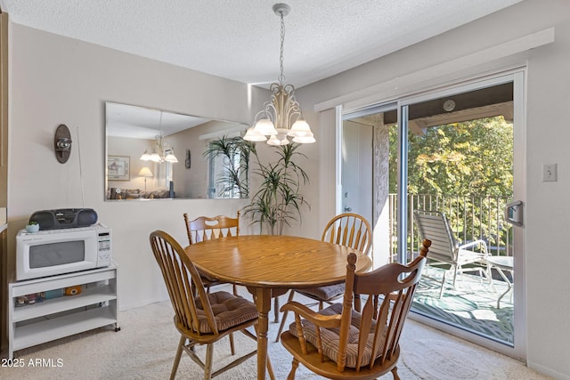 dining area with a textured ceiling and a chandelier