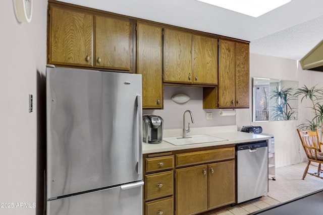 kitchen with stainless steel appliances, sink, and a textured ceiling