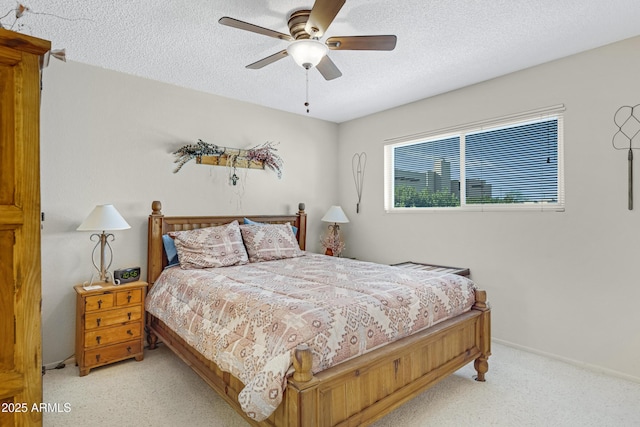 bedroom featuring ceiling fan, light colored carpet, and a textured ceiling