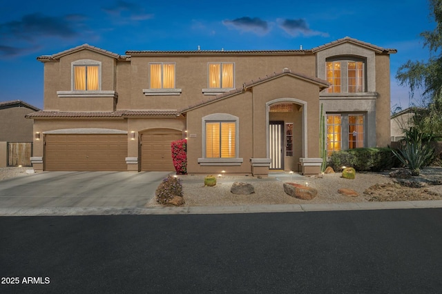 mediterranean / spanish home featuring concrete driveway, a tile roof, an attached garage, and stucco siding